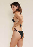 Model wears Tama string bikini bottom side view