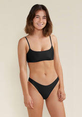Model wearing medium rise Blake bikini bottom in black