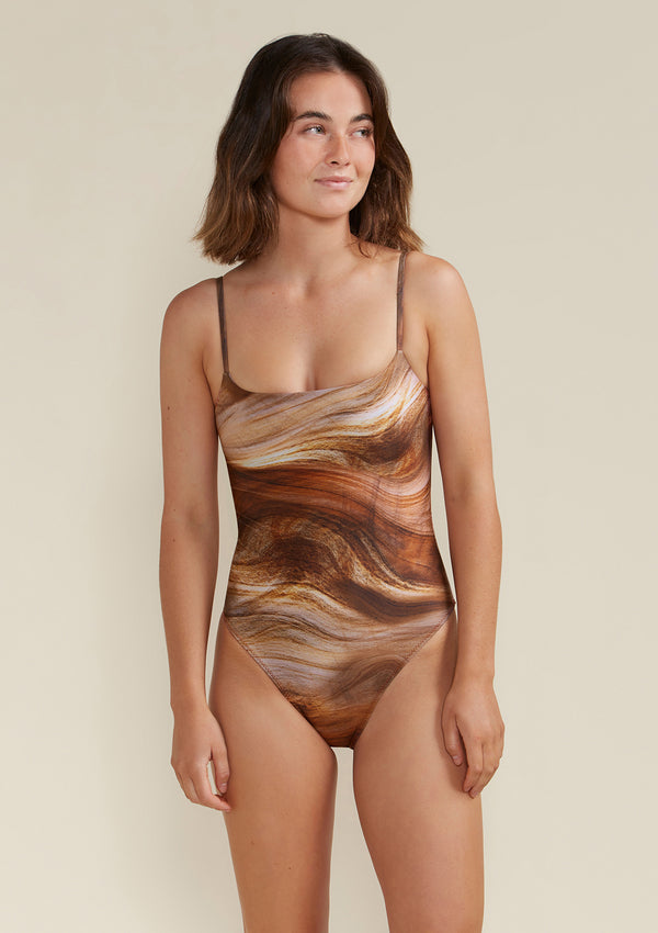 Model wearing Tama Swim Harlow one piece swimsuit in gaia print